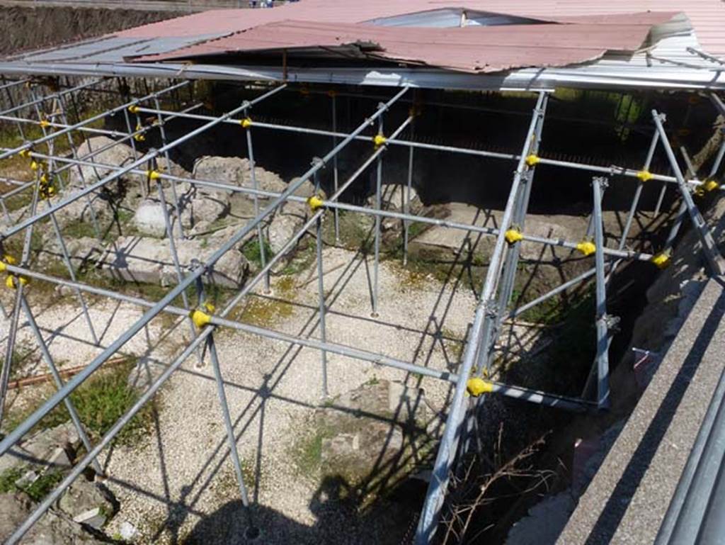 Villa dei Papiri, Herculaneum. June 2012. Looking west towards area of collapsed “monumental structure”,
Photo courtesy of Michael Binns.
According to Guidobaldi, found, at a much lower level than the noble floor of the villa and in a position nearer to the sea and lapped by it in the Roman age, was a collapsed structure, still to be excavated and which could coincide with the entrance to the villa from the sea. The structures now identified and detected include a terrace paved in cocciopesto and with steps down to the beach, on which opens a large quadrangular room, punctuated by large openings on all sides and decorated inside by precious sculptures (A beautiful copy of the Amazon of Polykleitos and a draped female statue that echoes models that can be traced back to the classical age of Agoracritus sculptures).
Le strutture per ora individuate e rilevate comprendono una terrazza pavimentata in cocciopesto e con scaletta di discesa alla spiaggia, su cui si apre una grande sala quadrangolare, scandita da grandi aperture su tutti i lati e decorata al suo interno da pregiate sculture (una bella copia dell’ Amazzone di Policleto e una statua femminile panneggiata che riecheggia modelli riconducibili allo sculture di età classica Agoracrito).
See Guidobaldi, M. P., 2006. Ercolano: guida agli scavi. Electa Napoli, (p.129).